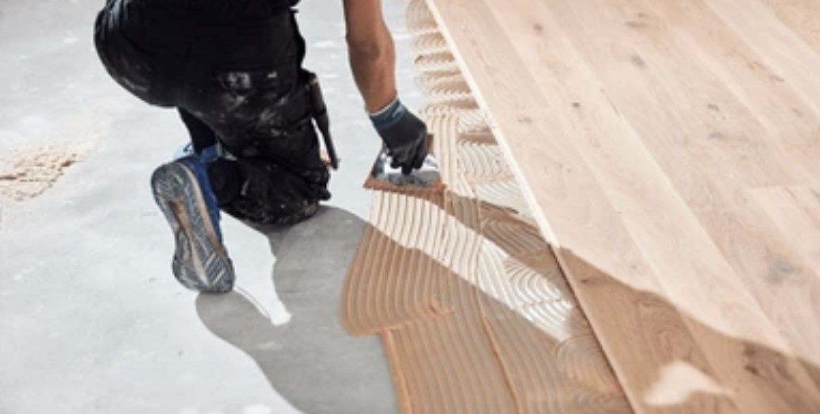 mężczyzna kładący panele podłogowe